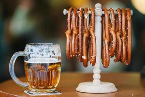Close up salted soft pretzels and beer on wooden background. photo