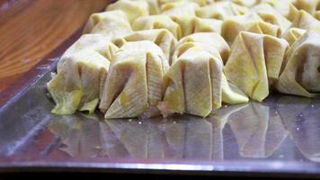 woman cooking traditional chinese dumplings or dumplings , close up video