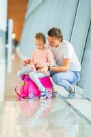 Happy family with two kids in airport have fun waiting for boarding photo