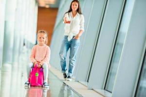 mamá feliz y niña con tarjeta de embarque en el aeropuerto foto