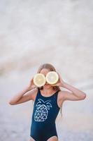 Adorable little girl have fun at tropical beach during vacation photo