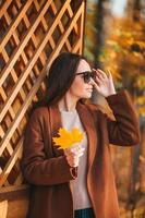 hermosa mujer en el parque de otoño bajo el follaje de otoño foto