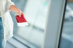 Primer plano de manos femeninas con pasaportes y tarjeta de embarque en el aeropuerto foto