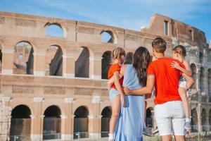 Happy family in Europe. Parents and kids in Rome over Coliseum background photo