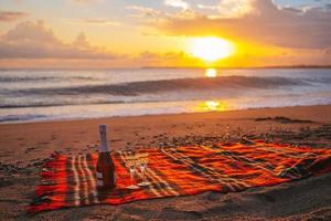 Having a picnic on the beach at sunset photo