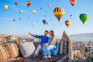 Happy young couple during sunrise watching hot air balloons in Cappadocia, Turkey photo