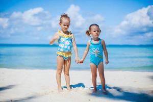 Adorable little girls have a lot of fun on the beach photo