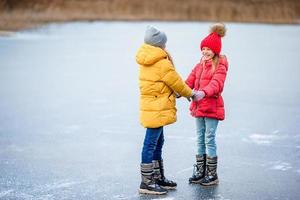 adorables niñas patinando en la pista de hielo foto