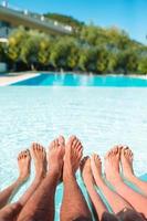 Close up of four people's legs by pool side photo