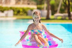 Adorable little kid play in outdoor swimming pool photo