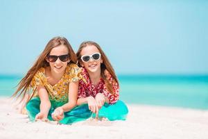 dos niñas felices se divierten mucho en la playa tropical jugando juntas foto