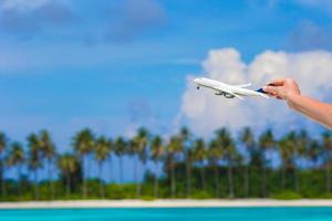 Small white miniature of an airplane on background of turquoise sea photo