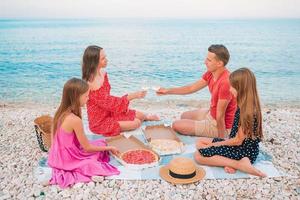 familia haciendo un picnic en la playa foto