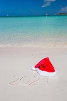 2016 written on tropical beach white sand with xmas hat photo