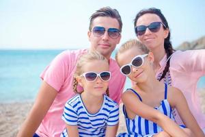 Young beautiful family taking selfie on the beach photo