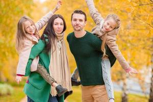 hermosa familia feliz de cuatro en el día de otoño al aire libre foto