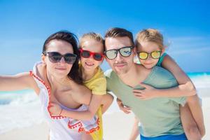 Young beautiful family taking self portrait on the beach photo