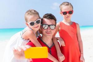 Young beautiful family taking selfie portrait on the beach photo