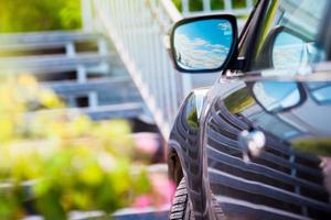 espejo de coche reflejo del cielo azul soleado en el espejo lateral del coche. foto