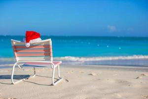 Santa hat on chair longue at tropical white beach photo