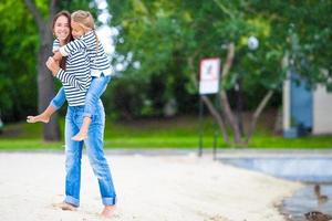 Happy mom and adorable little girl enjoying summer weekend photo