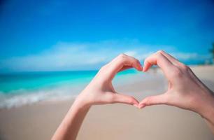 Hands in the shape of heart on the background of the Caribbean Sea photo