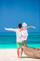 niña y padre joven durante las vacaciones en la playa tropical foto