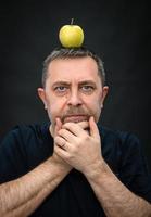 hombre con una manzana verde en la cabeza foto