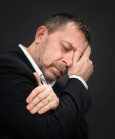 dolor de cabeza. hombre con la cara cerrada a mano foto