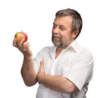 hombre de mediana edad sosteniendo una manzana roja foto