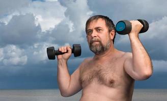 man exercising with dumbbells photo