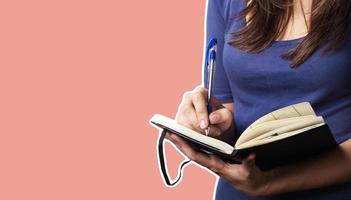 mujer joven con un bolígrafo y un cuaderno. foto