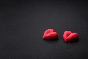 Delicious sweet heart shaped chocolate candies on a dark concrete background photo