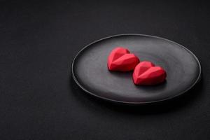 Delicious sweet heart shaped chocolate candies on a dark concrete background photo