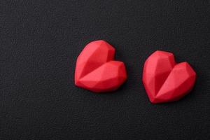 Delicious sweet heart shaped chocolate candies on a dark concrete background photo