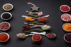 Composition consisting of a variation of spices in metal spoons laid out in the shape of a Christmas tree photo