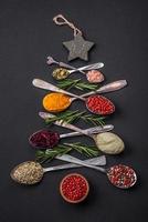 Composition consisting of a variation of spices in metal spoons laid out in the shape of a Christmas tree photo