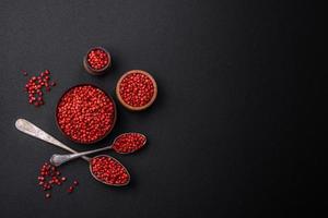Spice, allspice peas of red or pink color in a wooden bowl photo