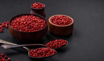 Spice, allspice peas of red or pink color in a wooden bowl photo