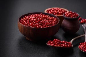 Spice, allspice peas of red or pink color in a wooden bowl photo