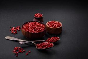 Spice, allspice peas of red or pink color in a wooden bowl photo