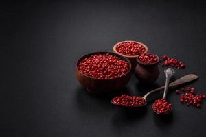 Spice, allspice peas of red or pink color in a wooden bowl photo