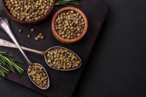 Spice, allspice green in a wooden bowl on a black concrete background photo