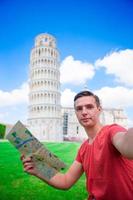 Young boy with toristic map on travel to Pisa. Tourist traveling visiting The Leaning Tower of Pisa. photo