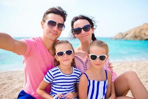 Young beautiful family taking selfie on the beach photo