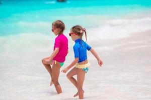 Kids having fun at tropical beach playing together at shallow water photo