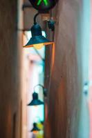 Old beautiful very narrow street in Prague. Close-up of a street light at the town house photo