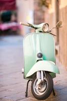 Light blue scooter on the street of the old city. Old classic european city elements photo