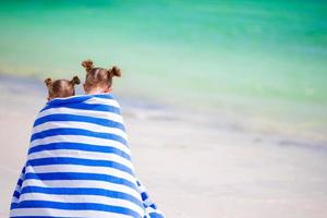 niñas envueltas en una toalla arter nadando en la playa tropical foto