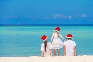 Young family in Santa hats during Christmas vacation photo